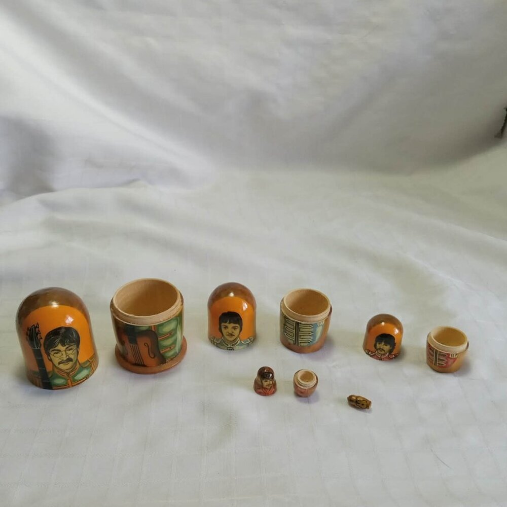 Russian dolls depicting The Beatles and a tiny guitar, hand-painted by a local